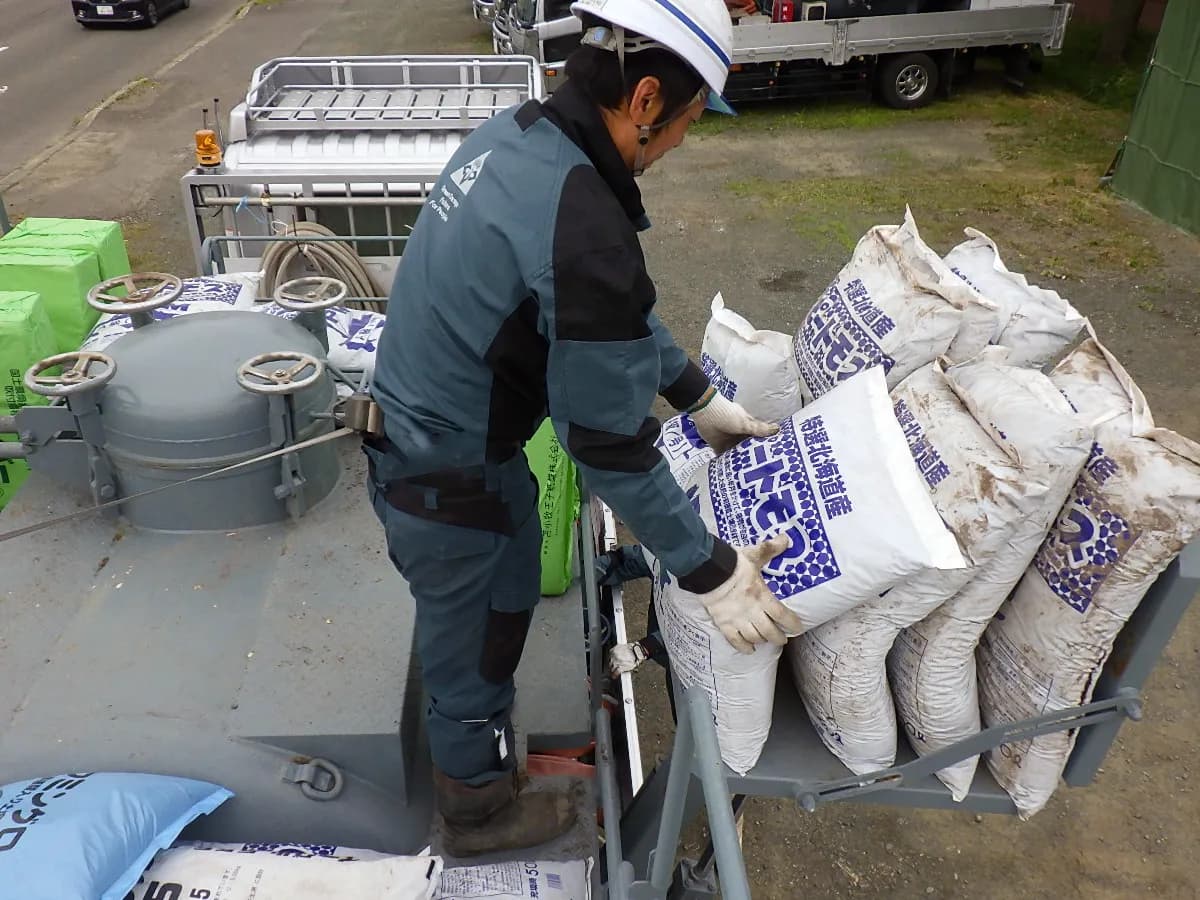 荷揚げ機で資材を機械上部まで搬送する作業